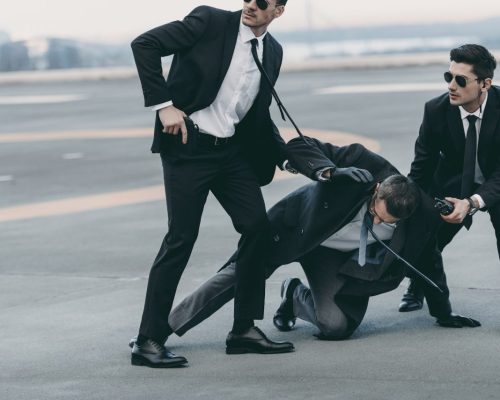 cropped-image-of-two-bodyguards-protecting-falling-businessman